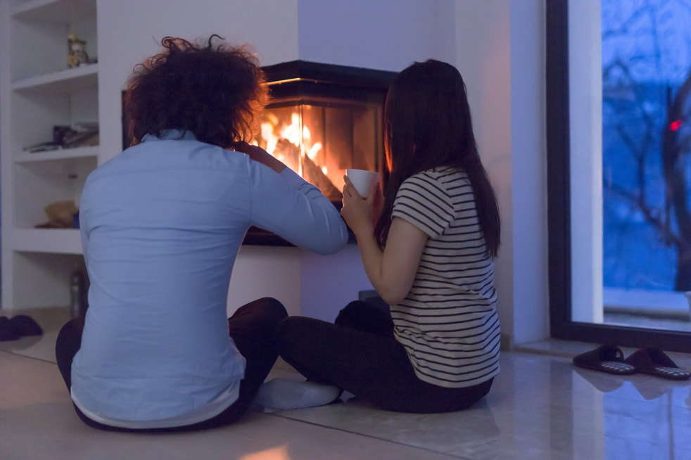 Young couple from Magog, spending quality time near the fireplace, following the passage of Magog Chimney Sweep.